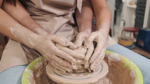 Couple Hands Making a Pot on a Pottery Workshop alt
