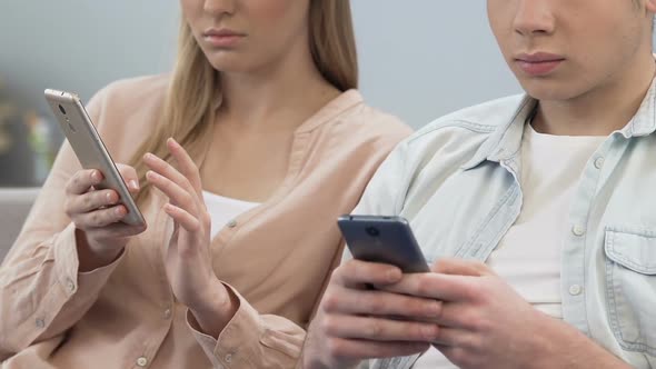 Two Students Downloading Application on Cellphone, Lack of Live Communication alt
