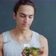 Slow Motion Portrait of Young Man Holding Plate of Salad and Fork Smiling on Grey Background - VideoHive Item for Sale