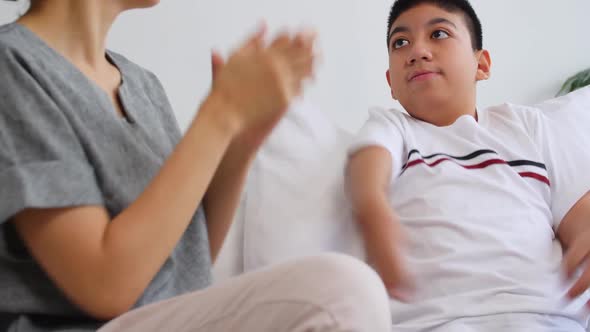 Asian mother caring for disabled son while living together at home alt