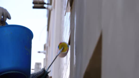 Industrial Climber Primers the Wall of Building with a Roller. Slow Motion alt