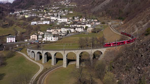 Train on Brusio Spiral Viaduct in Switzerland alt