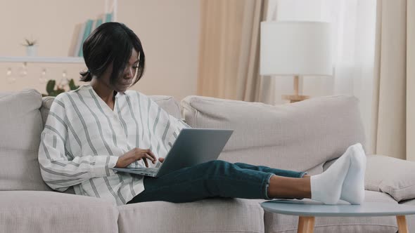 Young Focused Businesswoman Freelancer Typing on Laptop Working Remotely at Home Using Computer alt