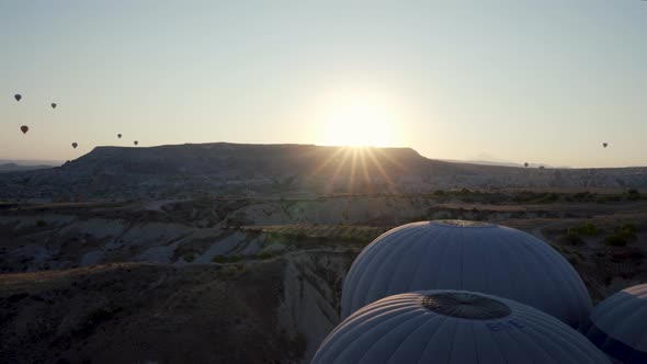 Drone shot of huge hot air balloon flying over idyllic Love Valley in natural park alt