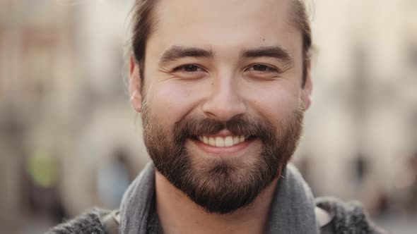 Portrait of a Bearded Happy Man Who is Looking at the Camera and Smiling alt
