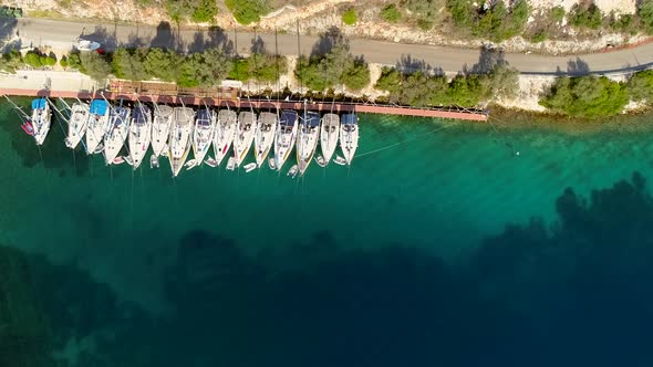 Aerial view small group of boats anchored at harbor on the coast of Fiskardo. alt