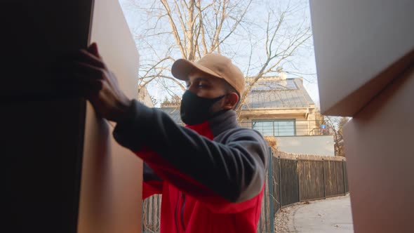 Young Courier Unloading Parcels From the Truck alt