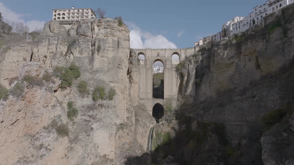 Aerial view of dramatic medieval arch bridge over gorge in Ronda Spain alt