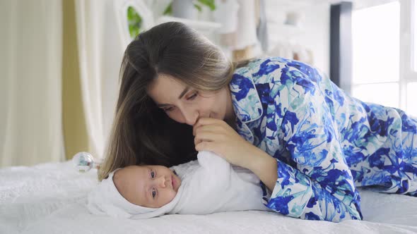Mother with Long Loose Flowing Hair Kisses Little Infant