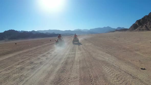 Sexy Woman Is Riding a Quad Bike in the Desert of Egypt. Dynamic View in Motion. alt