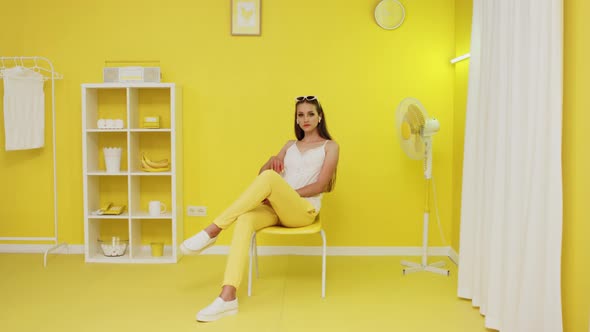 Portrait of Beautiful Woman Sitting In Yellow Interior alt
