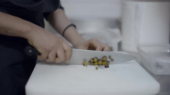 Close Side View of Chef Slicing Vegetables on Kitchen Counter No Face alt