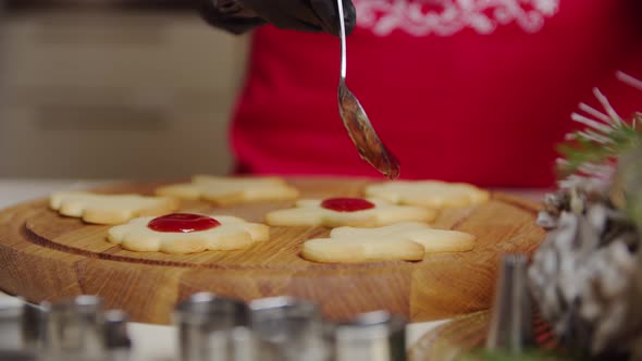 Close Up View of a Woman Hand Making a Gingerbread Cookie Using a Spoon Puts the Jam on the Cookies alt