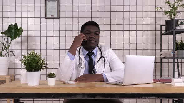 Concentrated Male Doctor Making a Call alt