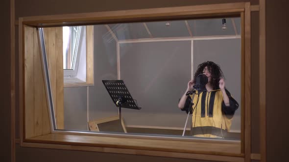 Young Modern Woman Singer is Recording a Song in a Recording Studio alt