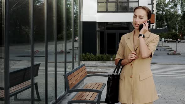 Adult Caucasian Confident Young Business Woman is Talking on Phone Outside  alt