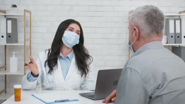 Female Doctor Consulting Senior Male Patient Sitting In Clinic Office alt