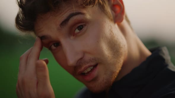 Young Guy Flirting with Camera. Hot Model Guy Looking at Camera Outdoors alt