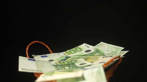 Falling Euro bills in a symbolic wicker basket as a money rain symbol