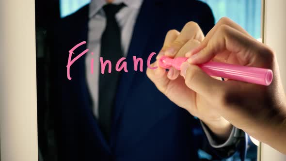 Smart Business Man Writing the Word FINANCE on the Mirror Board alt