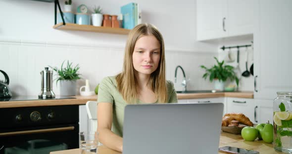 Young Confident Business Woman Portrait at Home with Laptop in Kitchen at Home