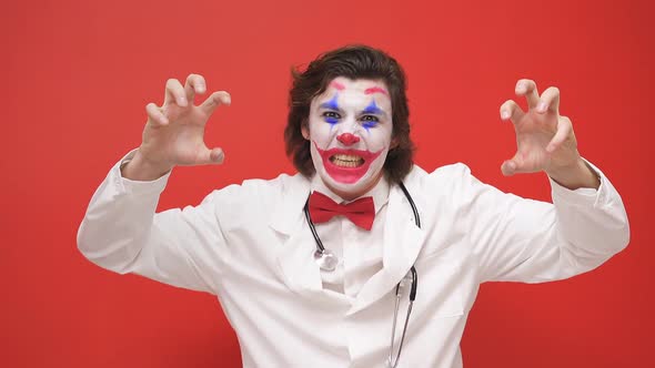 a Strange Male Clown Screams Into the Camera Arms Outstretched alt