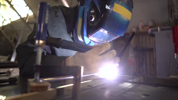 Professional Welder Working With Argon-Arc Welding At Plant. Camera Moves Forward.