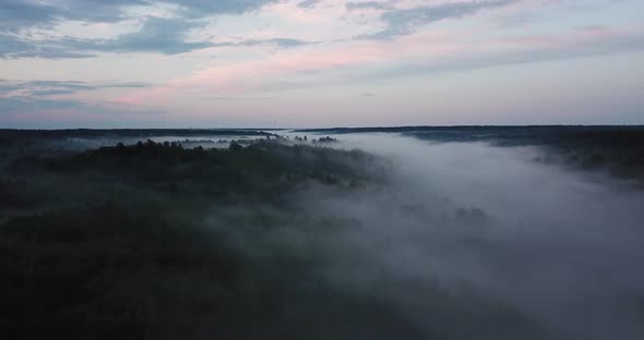 Autumn forest aerial. Low clouds of fog over trees. Misty weather, colorful woods. alt