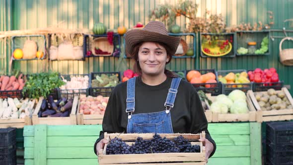 Woman Farmer (Seller) With Grapes at the Farmer's Market. alt