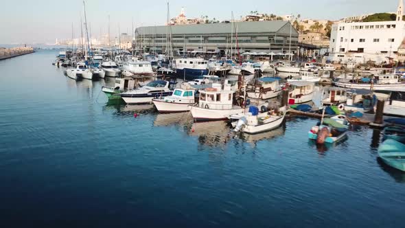 Beautiful clip ascending to overview shot of Jaffa harbor with fishing boats and boats while at the alt
