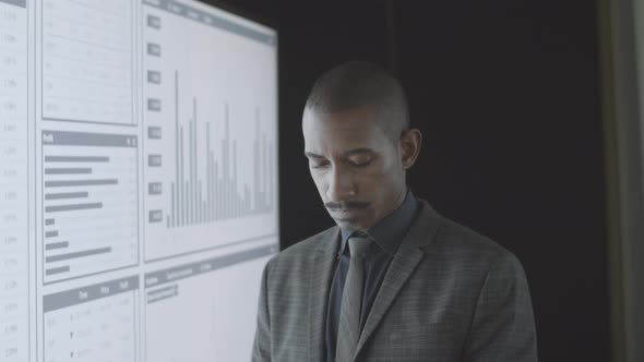 Serious Black Financial Trader Analyzing Trading Charts alt