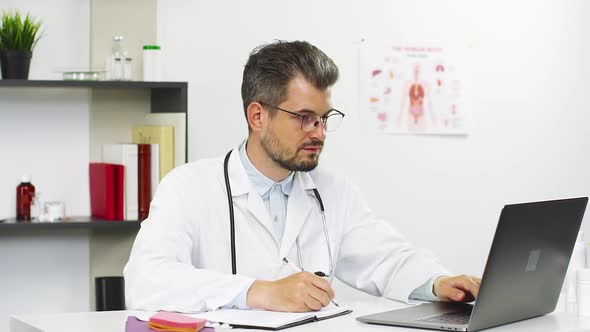 Modern Doctor Working with Medical Files and Computer alt