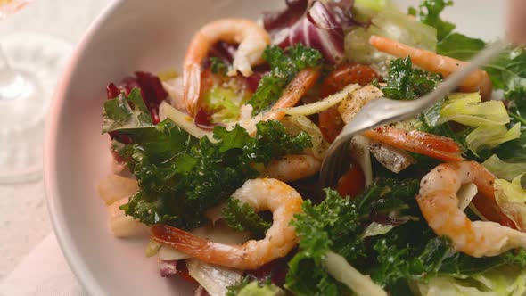 Lettuce, baked prawns, cheese and tomatoes are served with oil and herbs on top