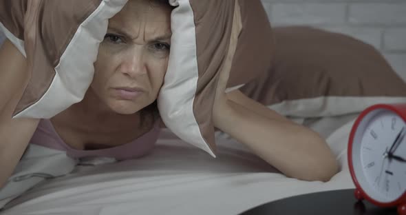Irritated woman try to sleep.  alt