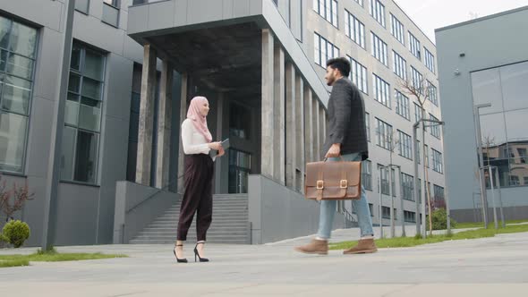 Side View of Muslim Business Partners in Formal Clothes Standing on Street and alt