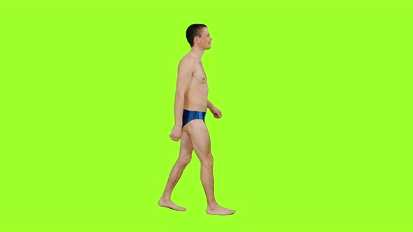 Walking Young Sporty Man in Swim Trunks