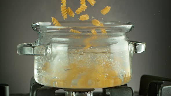Super Slow Motion Shot of Fresh Fusilli Falling Into Boiling Salted Water at 1000 Fps. alt