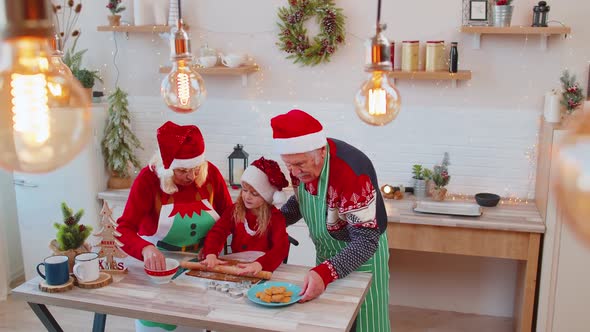 Grandparents with Granddaughter Preparing Cooking Homemade Cookie Roll Out Dough Christmas Kitchen alt