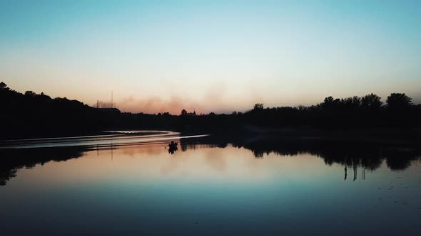 A gondolier is floating on a quiet river at sunset on a warm summer evening. Wonderful view. alt