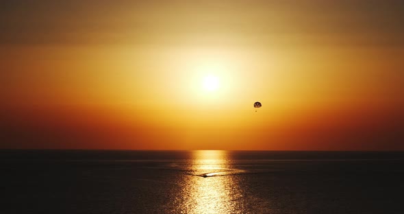 parasailing parascending parakiting,paragliding at cinematic sunset by boat in ten bit four k sixty alt