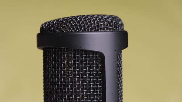 Studio Condenser Microphone Rotates on Yellow Background with Place for Text alt