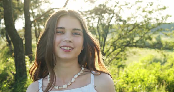 Attractive Smiling European Teen Girl with Natural Makeup Enjoys Moment Posing and Looks Into the alt