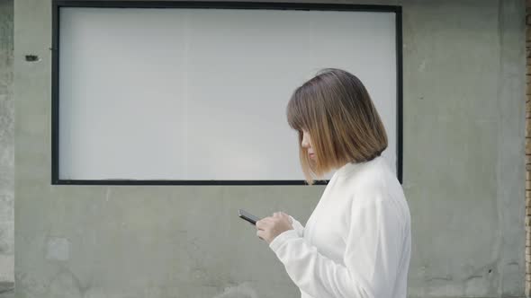 Asian tourist blogger woman using touchscreen technology at smartphone while walking