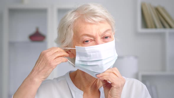 Smiling aged businesswoman with blue eyes looks straight alt