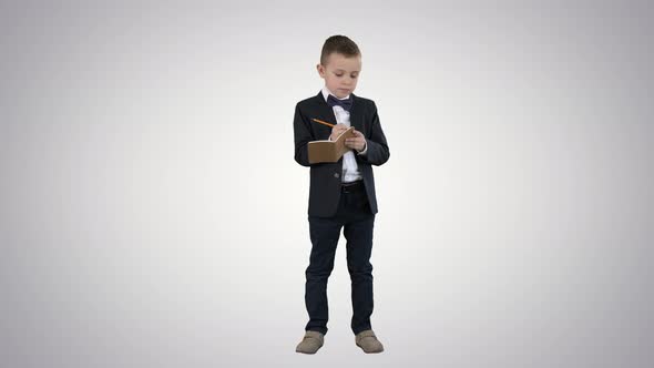 Back To School Little Boy Putting Down Ideas on Gradient Background. alt