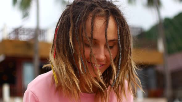 A Woman with Dreadlocks Plays a Musical Instrument and Enjoys Music alt