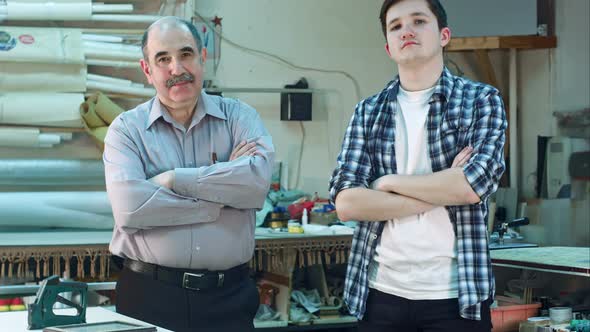 Portrait of Two Workers, Standing in Workshop and Looking at Camera Seriously alt