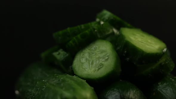 Sliced Fresh Green Cucumbers Rotate On A Black Background