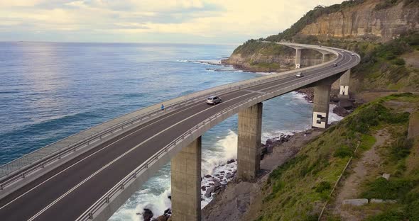 Cars Driving Along Sea Cliff Bridge alt