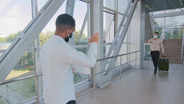 Afro American Colleague Partner Worker in Medical Protective Mask Meets Hispanic Business Man alt